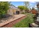 Landscaped backyard with stone patio, lush lawn, mature trees, and outdoor seating at 11031 Marshall St, Westminster, CO 80020