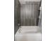 Modern bathroom featuring a sleek bathtub with tiled wall and convenient shelving for storage at 11031 Marshall St, Westminster, CO 80020