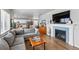 Spacious living room with a fireplace and a seamless connection to the modern kitchen and dining area at 11744 Magnolia Dr, Thornton, CO 80233
