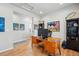 Bright office with wood desk and floors, and quirky art on the walls at 11744 Magnolia Dr, Thornton, CO 80233