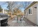Back deck with outdoor dining area, grill and trees in the background, ideal for enjoying outdoor meals at 15865 E Kepner Dr, Aurora, CO 80017