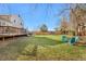 Large backyard with an expansive lawn, deck with grill and seating area, and a trampoline for outdoor fun at 15865 E Kepner Dr, Aurora, CO 80017