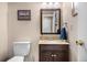 Half-bath features a dark wood vanity with a tan countertop and a decorative sign at 15865 E Kepner Dr, Aurora, CO 80017