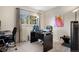 Home office including two desks, rolling chairs, a large window, and neutral carpet at 15865 E Kepner Dr, Aurora, CO 80017