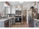 Updated kitchen with stainless steel appliances, stylish backsplash, and sink under the window creates a functional and appealing space at 15865 E Kepner Dr, Aurora, CO 80017