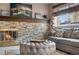 Inviting living room with stone fireplace, cozy seating, wooden blinds, and artwork above the mantel at 15865 E Kepner Dr, Aurora, CO 80017