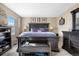 Spacious bedroom with a dark wood bed frame, dark furniture, and a window letting in natural light at 15865 E Kepner Dr, Aurora, CO 80017