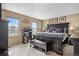 Bright bedroom with a large bed frame, a bookcase, a bench, and a dresser at 15865 E Kepner Dr, Aurora, CO 80017