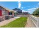 Beautifully landscaped backyard with a stone accent, concrete patio, and white fence, enhancing the property's appeal at 11129 Paradise Ln, Firestone, CO 80504