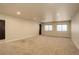 Spacious basement with neutral carpet, windows, and a dark door at 11129 Paradise Ln, Firestone, CO 80504