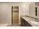 Bathroom featuring granite countertops, double sinks, decorative mirror, a walk-in closet and a walk-in shower at 11129 Paradise Ln, Firestone, CO 80504