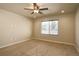Light-filled bedroom featuring carpet, neutral walls, a ceiling fan, and a large window for natural light at 11129 Paradise Ln, Firestone, CO 80504