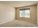 Bright, carpeted bedroom with a large window providing ample natural light and views of the outdoors at 11129 Paradise Ln, Firestone, CO 80504