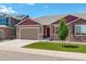Inviting home exterior with a neatly kept lawn, two-car garage, and appealing stone veneer details at 11129 Paradise Ln, Firestone, CO 80504