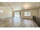 Open-concept living room with wood-style flooring, ceiling fan, chandelier, and sliding glass doors to the backyard at 11129 Paradise Ln, Firestone, CO 80504