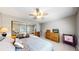 Spacious bedroom featuring a large closet with mirrored doors, fan, and TV at 13626 E Bates Ave # 302, Aurora, CO 80014