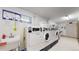 Clean laundry room with multiple high-efficiency washers and dryers, plus folding area at 13626 E Bates Ave # 302, Aurora, CO 80014