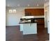 Kitchen with an island, dark countertops, and wooden cabinets at 16411 E 111Th Dr, Commerce City, CO 80022