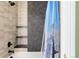 Modern bathtub with black fixtures, gray tile surround, and mountain-themed shower curtain at 5301 S Birch Ct, Greenwood Village, CO 80121
