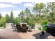 Outdoor deck featuring a dining table, chairs, lush trees, and a barbecue grill at 5301 S Birch Ct, Greenwood Village, CO 80121