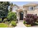 Charming home entrance with a beautiful garden, mature trees, and a covered front porch at 5301 S Birch Ct, Greenwood Village, CO 80121