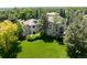 Backyard view of an elegant home with lush green grass, trees, and solar panels at 5301 S Birch Ct, Greenwood Village, CO 80121