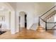 Elegant foyer with hardwood floors, staircase with white railings, and arched doorways at 5301 S Birch Ct, Greenwood Village, CO 80121