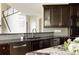 Modern kitchen with dark cabinets, stainless steel appliances, and sleek gray backsplash tiles at 5301 S Birch Ct, Greenwood Village, CO 80121