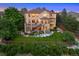 Expansive backyard with a multi-level deck, stone landscaping, lush lawn, and a wooded perimeter at 12147 S Shady Pine Ct, Parker, CO 80134