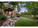 The home's outdoor space includes a stone patio, a wooden fence, and lush green grass at 12147 S Shady Pine Ct, Parker, CO 80134
