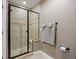 Clean bathroom featuring tiled shower with glass door, built-in seat, and neutral-toned walls at 12147 S Shady Pine Ct, Parker, CO 80134