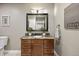 Bathroom vanity features granite countertop, dark wood cabinets, decorative mirror and sconce at 12147 S Shady Pine Ct, Parker, CO 80134