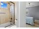 Bathroom featuring a tiled shower-tub combo with a glass door and a view into the next bedroom through the doorway at 12147 S Shady Pine Ct, Parker, CO 80134