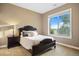 Cozy bedroom with a dark wood bed frame, side table, and a picturesque view from the window at 12147 S Shady Pine Ct, Parker, CO 80134