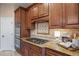 Well-equipped kitchen featuring granite countertops, wood cabinetry, and stainless steel appliances at 12147 S Shady Pine Ct, Parker, CO 80134