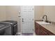Well-equipped laundry room with modern washer and dryer, sink, and storage cabinets for added convenience at 12147 S Shady Pine Ct, Parker, CO 80134