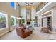 This living room boasts high ceilings, large windows, and a fireplace for a comfortable space at 12147 S Shady Pine Ct, Parker, CO 80134