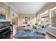 Bright living room features a piano, large windows, and cozy seating area with a colorful rug and throw pillows at 12147 S Shady Pine Ct, Parker, CO 80134