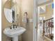Elegant powder room with a pedestal sink, decorative mirror, and adjacent staircase leading to the upper level at 12147 S Shady Pine Ct, Parker, CO 80134