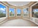 Sunroom with neutral walls, plush carpet and many windows providing a view of the surrounding forest at 12147 S Shady Pine Ct, Parker, CO 80134