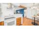 Open kitchen with modern appliances, stone countertops, white cabinets, and an eat-in area at 10251 W 44Th Ave # 7-106, Wheat Ridge, CO 80033