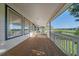 Long covered back porch with railing overlooking green fields at 10125 Quarry Hill Pl, Parker, CO 80134