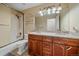 Bathroom with granite double vanity, a shower and tub combination, and decorative lighting at 10125 Quarry Hill Pl, Parker, CO 80134