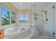 Beautiful bathroom featuring a tub, a separate glass shower, and natural light at 10125 Quarry Hill Pl, Parker, CO 80134