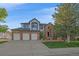 Inviting brick home boasts a three-car garage and beautifully landscaped front yard at 10125 Quarry Hill Pl, Parker, CO 80134
