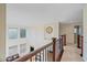 Hallway overlooking the living room with hardwood floors, a large clock and a decorative railing at 10125 Quarry Hill Pl, Parker, CO 80134