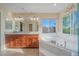 Bright main bathroom with double vanity, soaking tub, large window and enclosed glass shower at 10125 Quarry Hill Pl, Parker, CO 80134