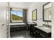 Modern bathroom with dual sinks, black cabinets, granite countertops and scenic views at 10508 Christopher Dr, Conifer, CO 80433