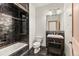 A bathroom with dark tile features a vanity and tub with shower at 10508 Christopher Dr, Conifer, CO 80433