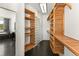 A modern walk-in closet with wooden shelves, cabinets and a glass block wall at 10508 Christopher Dr, Conifer, CO 80433